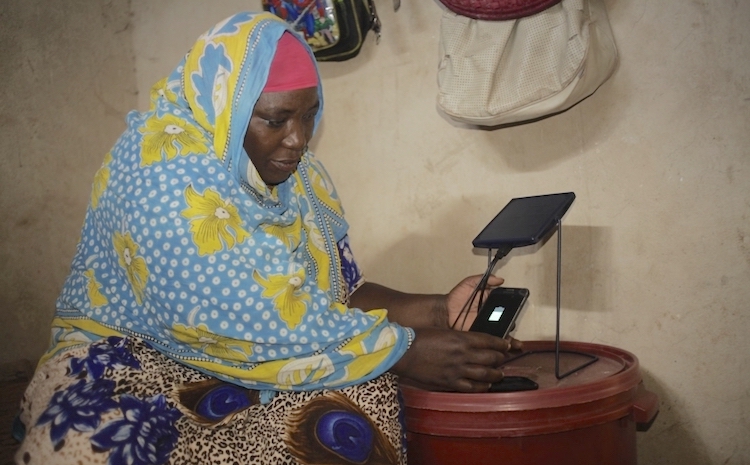 Photo: Mariam Kassim Salum charging her phone on a solar equipment at Kizimkazi village in Zanzibar, Tanzania. Courtesy: Barefoot College