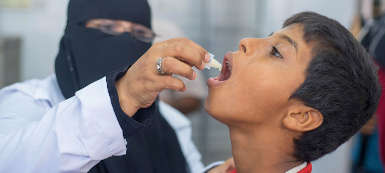 Photo: A health worker administers a vaccination against cholera to a young boy in Yemen. Credit: UNICEF/Saleh Bahless