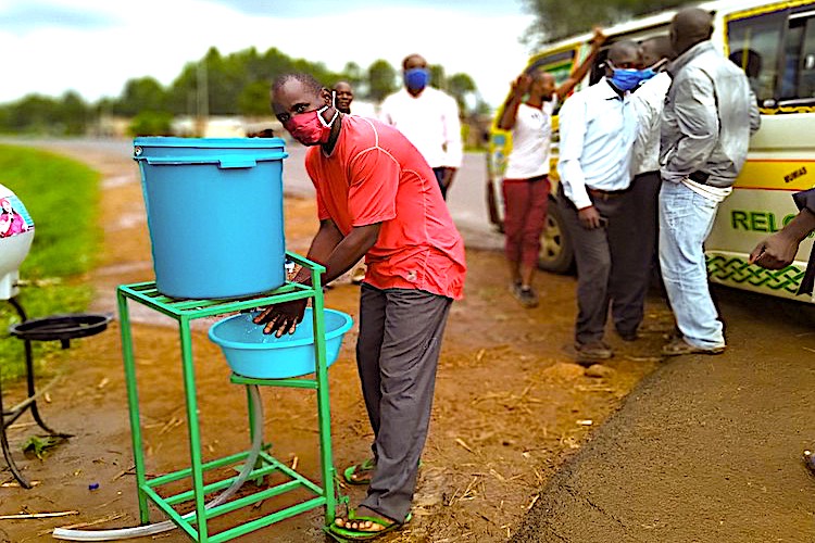 Photo: A passenger washing hands using the new device before boarding a public service vehicle at Muangatsi Market Centre Bus Stage, Busia County, Kenya. Credit: Kevin Wafula.
