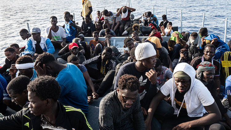 Photo: Migrants on board a boat headed for Tripoli in July 2019. Critics say the EU should not be helping the Libyan Coast Guard to intercept and return people to a war-torn country where they face abuse and extortion. (Filippo Rossi/TNH)
