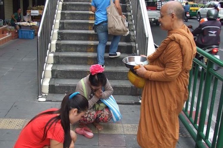 Photo: A common morning "merit making" ritual across Thailand where people give food to monks. Credit: Kalinga Seneviratne.