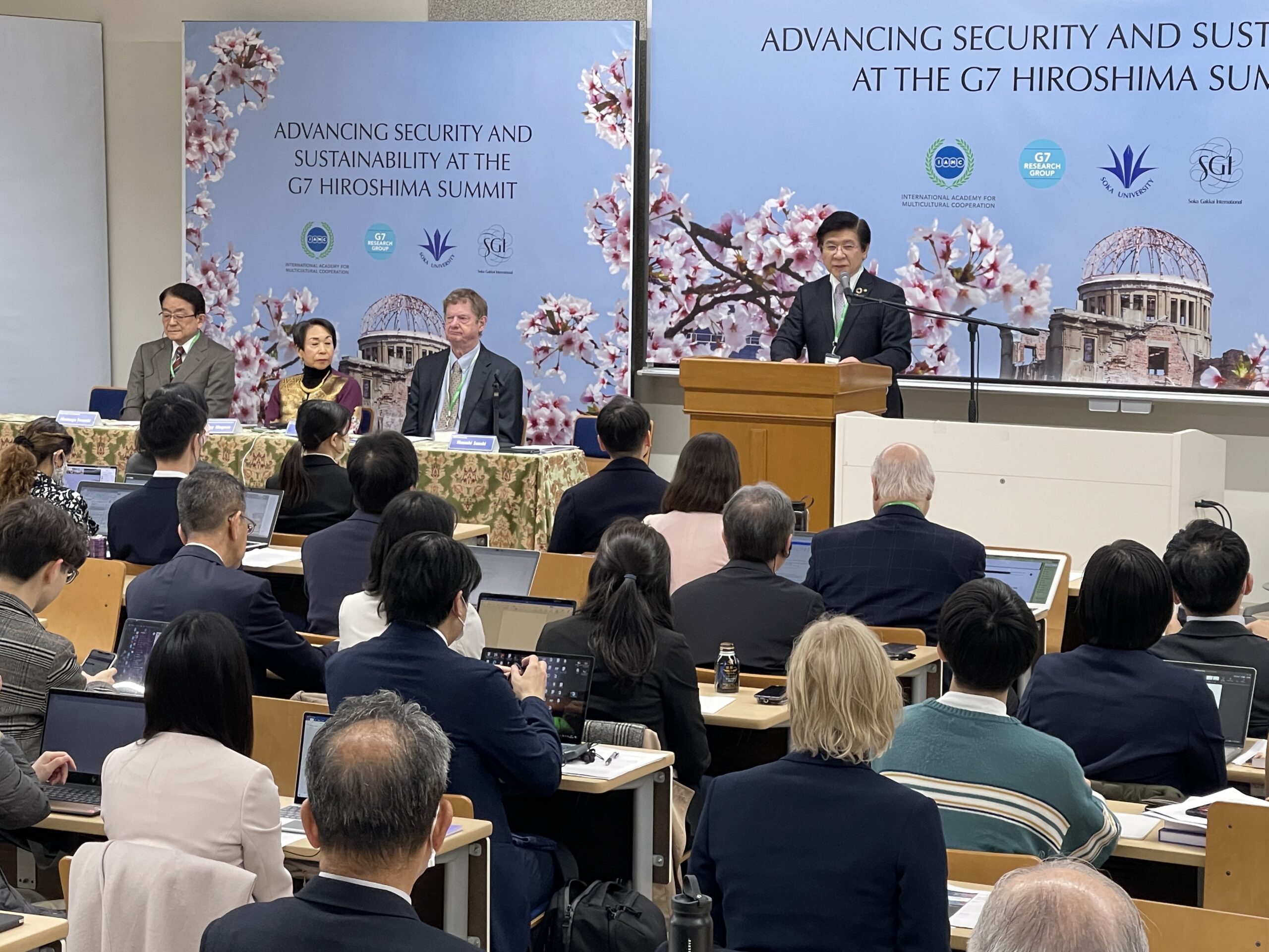Photo: Soka University President Masashi Suzuki making the welcoming speech at a one-day international conference titled ‘Advancing Security and Sustainability at the G7 Hiroshima Summit’ held at the University on March 29, 2023. (From left to right): Hirotsugu Terasaki, Director General, Peace and Global Issues, Soka Gakkai International (SGI), Audrey Kitagawa, President, International Academy of Multicultural Cooperation (IAMC), and John Kirton, Director, G7 Research Group. Credit: Katsuhiro Asagiri, Multimedia Director of IDN-INPS.
