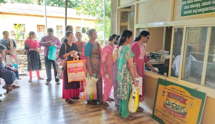 Photo: Beneficiaries of the Annabhagya Yojana standing in a queue outside the public distribution shop to collect the rice. Credit: Manjushree Naik.